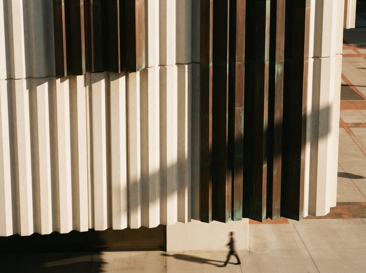 A close-up architectural macro shot of fluted concrete cladding under sharp morning raking light.
